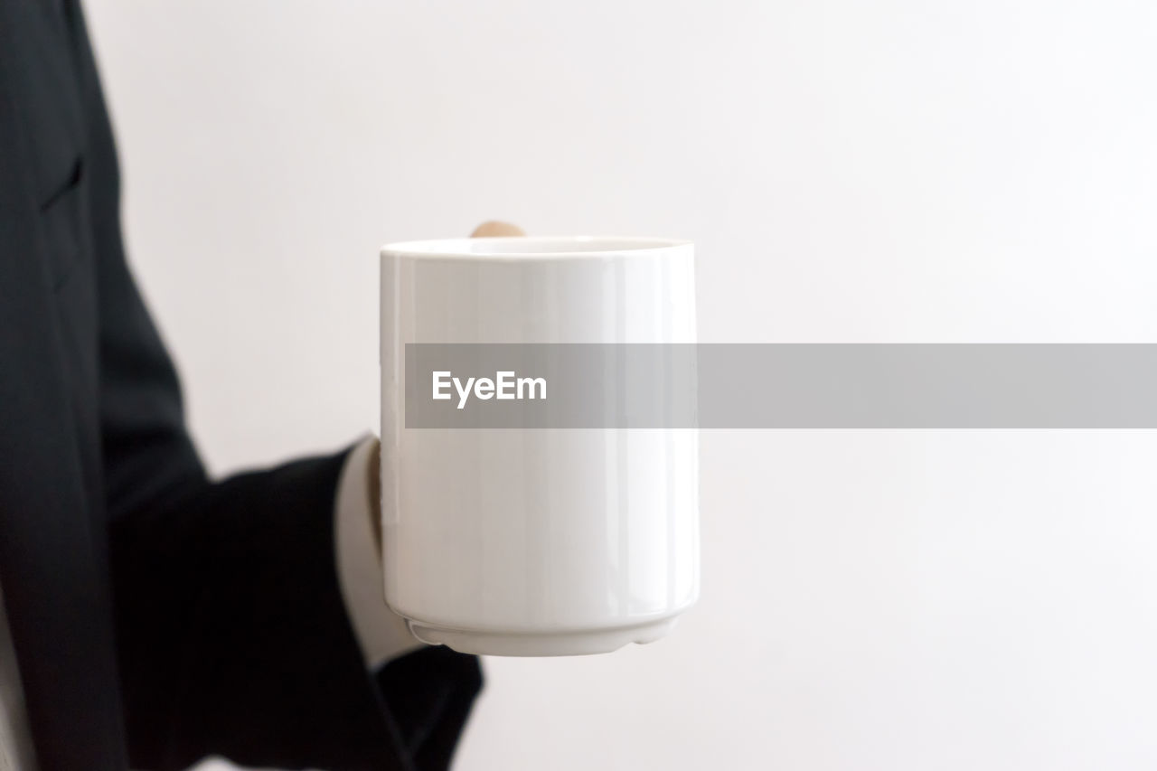 Businessman holding a white mug.