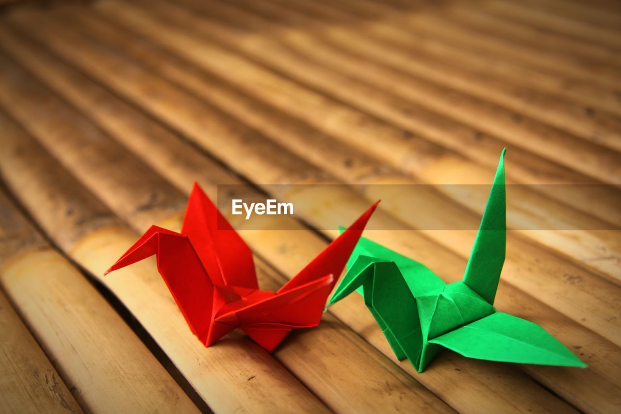 High angle view of paper cranes on wooden plank