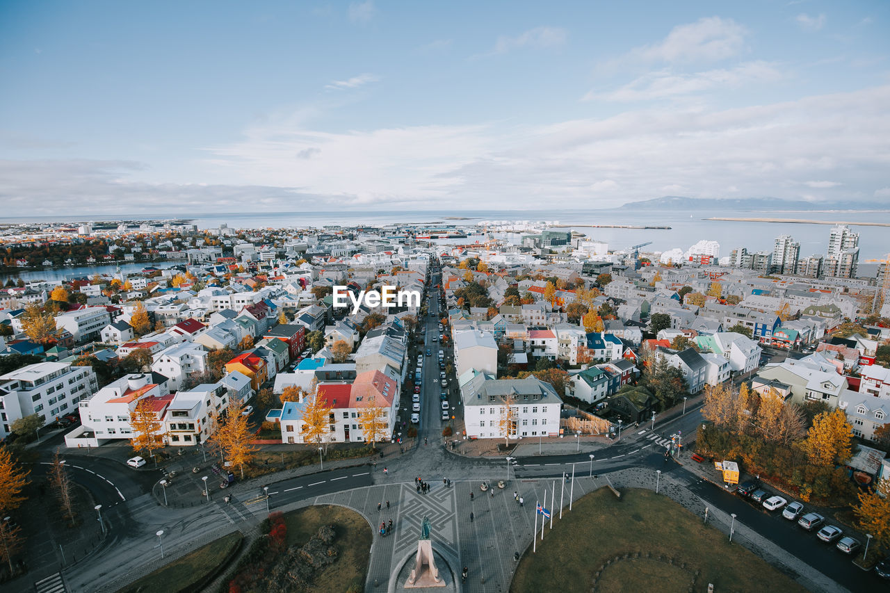 High angle view of townscape by sea against sky