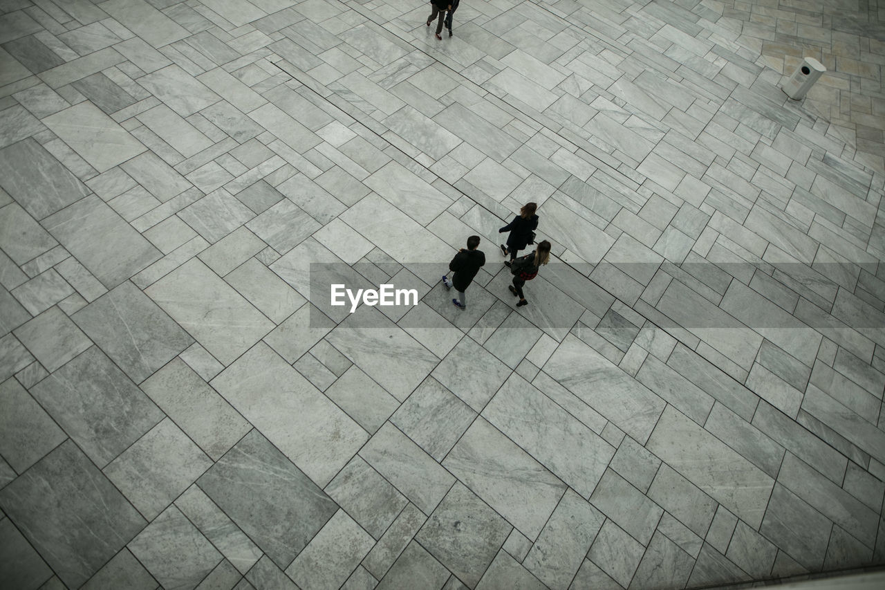 High angle view of friends walking on pedestrian zone