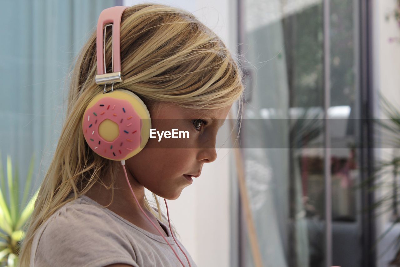 Profile view of girl wearing donut shape headphones