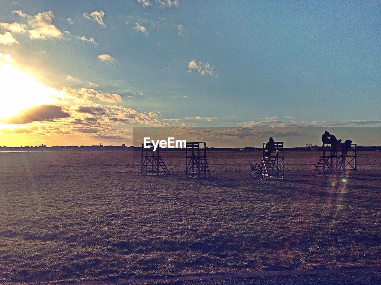 Lifeguard seats in field at sunset