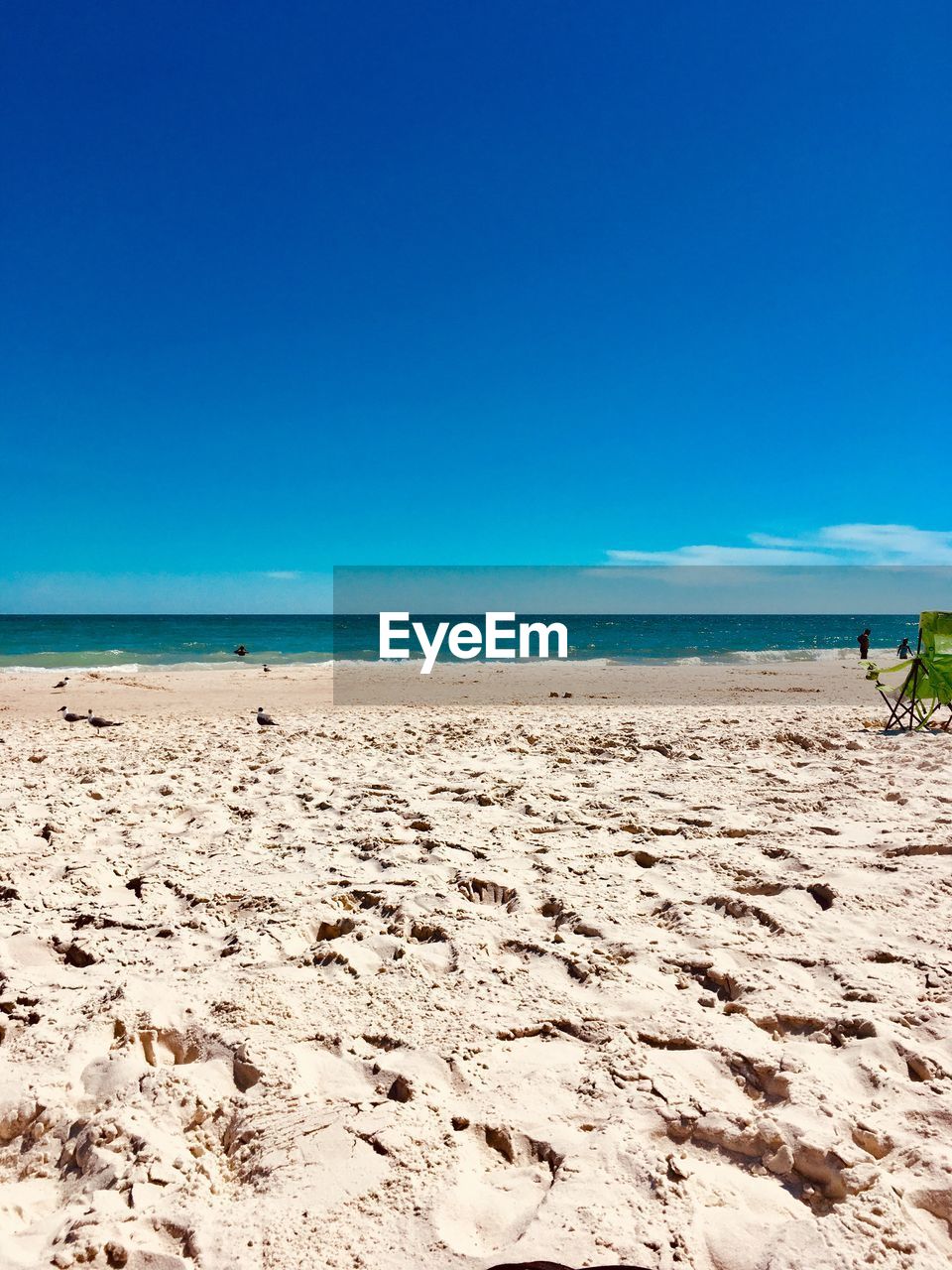 Scenic view of beach against clear blue sky