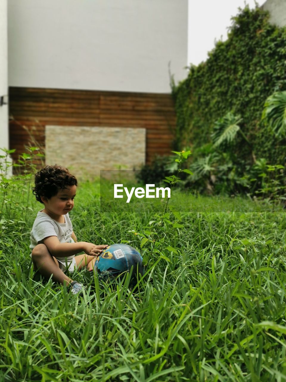 Boy sitting on grassy field outdoors