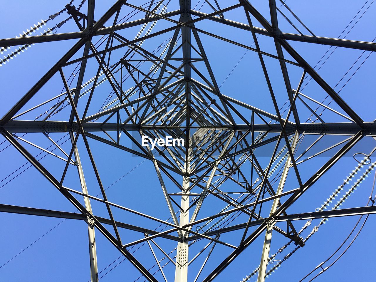 Directly above shot of electricity pylon against clear blue sky