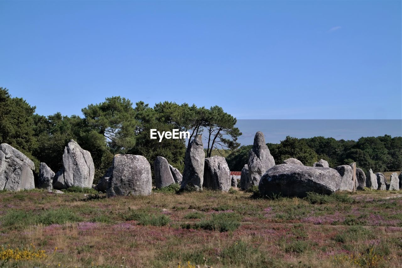 Rocks on field against clear sky