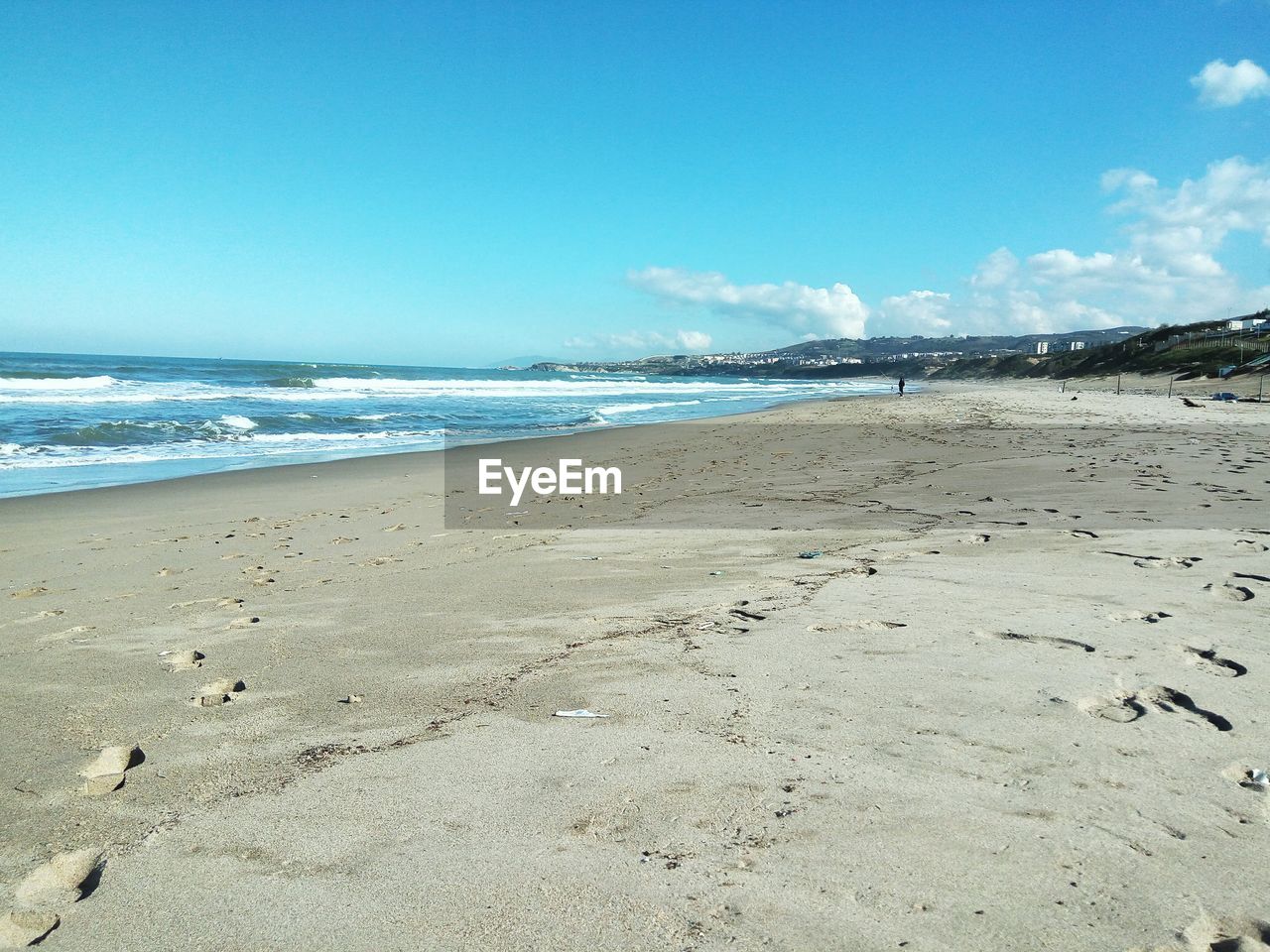 Scenic view of beach against blue sky