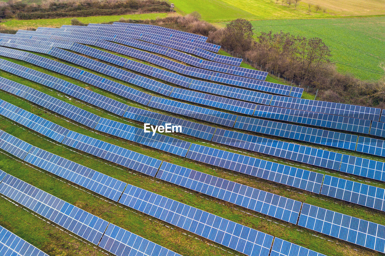 An solar park system between fields and meadows in germany from a drone perspective