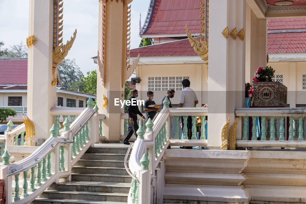 PEOPLE WALKING ON STAIRCASE OUTSIDE TEMPLE