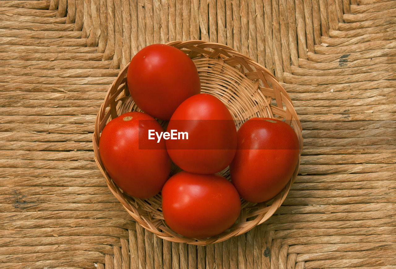 CLOSE-UP OF TOMATOES IN BASKET ON TABLE