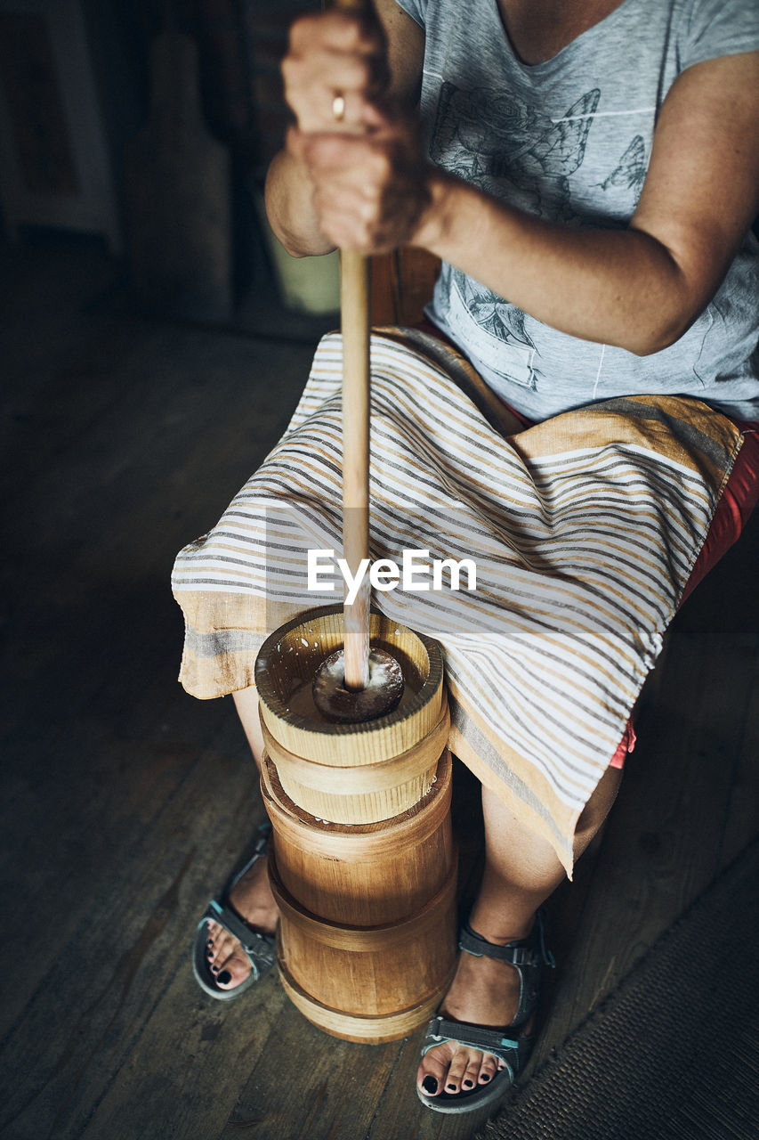 Woman making butter with butter churn. old traditional method making of butter