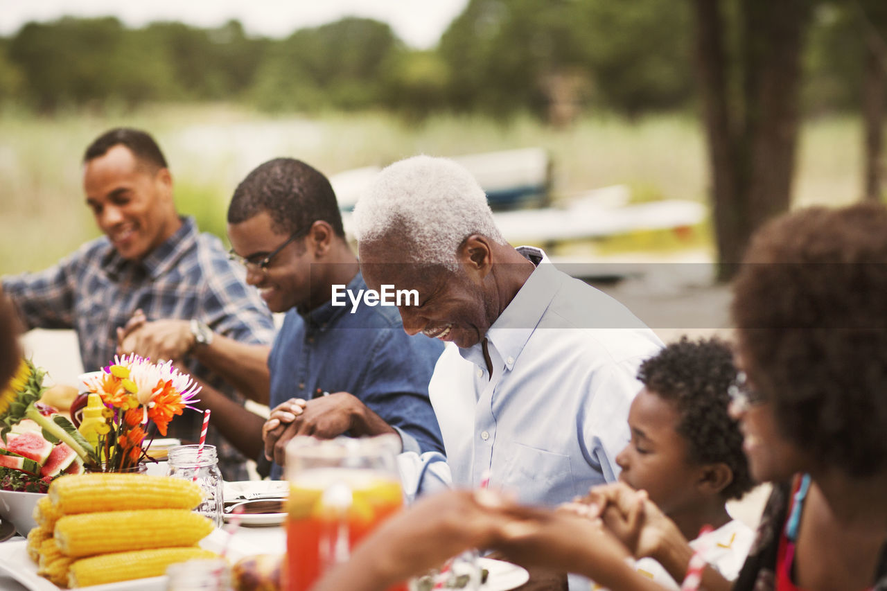 Happy family holding hands at breakfast table