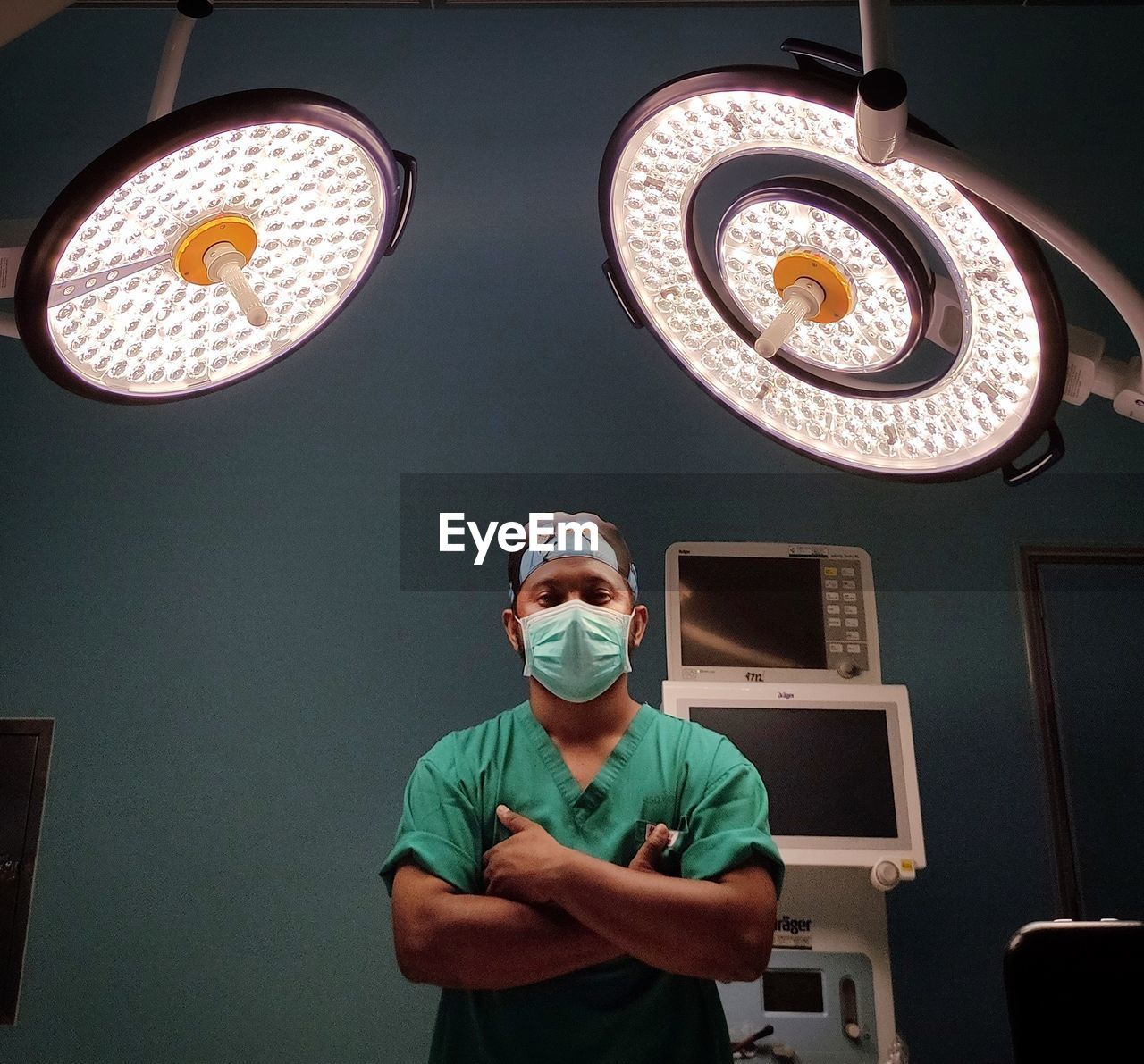 Portrait of surgeon wearing mask standing at operating theater