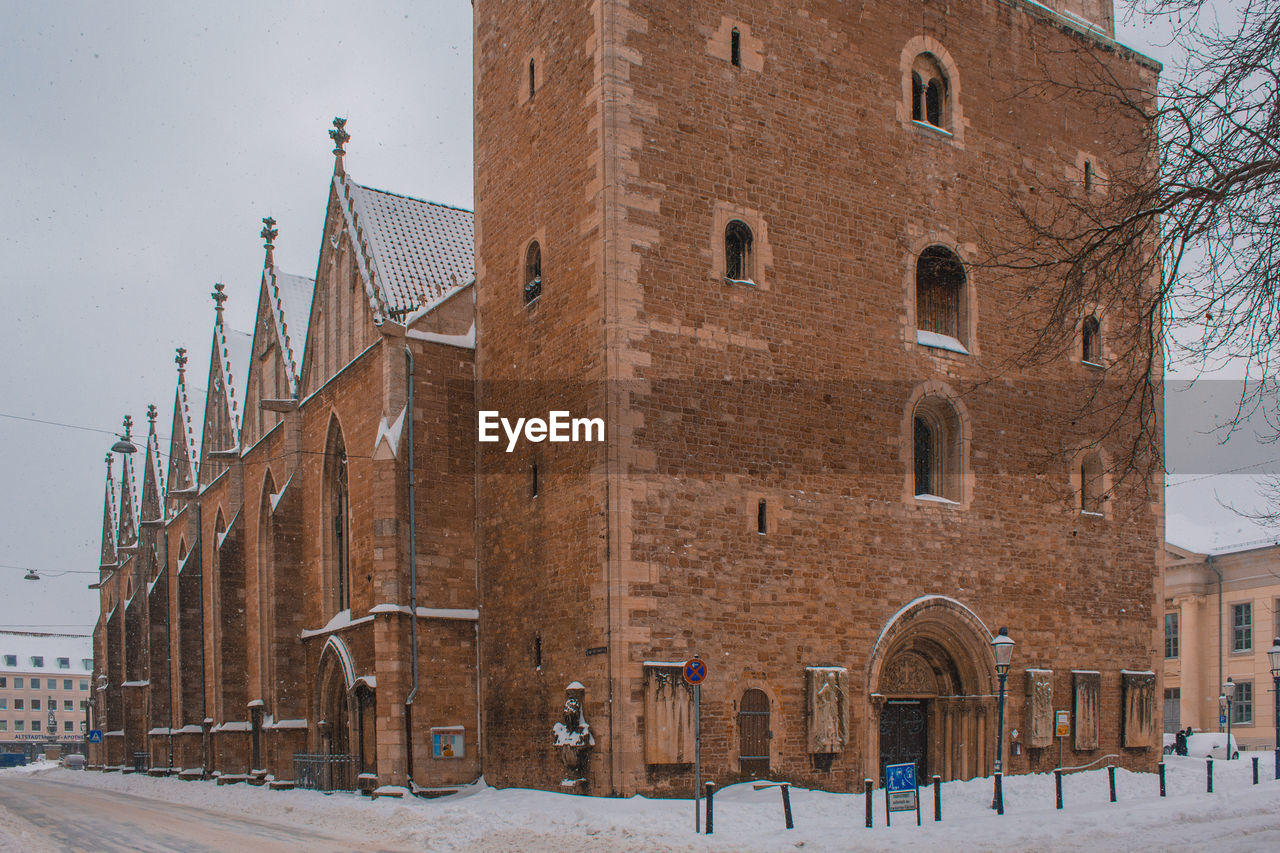 SNOW COVERED STREET BY BUILDINGS IN CITY