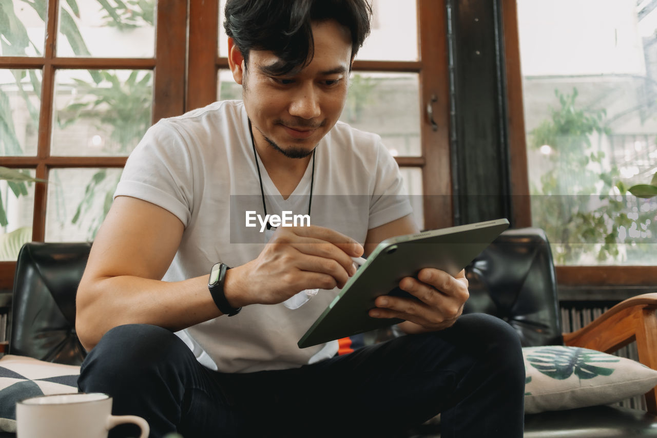 Man using digital tablet at cafe