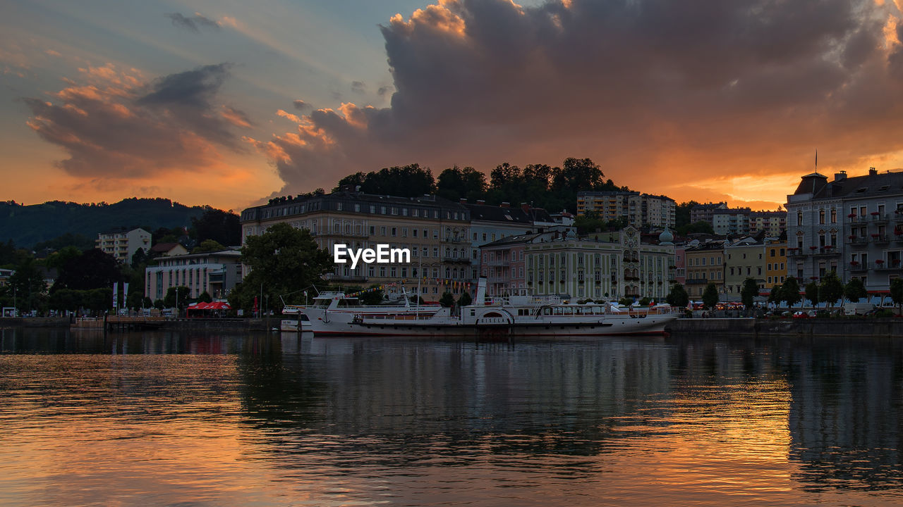 Buildings at waterfront during sunset