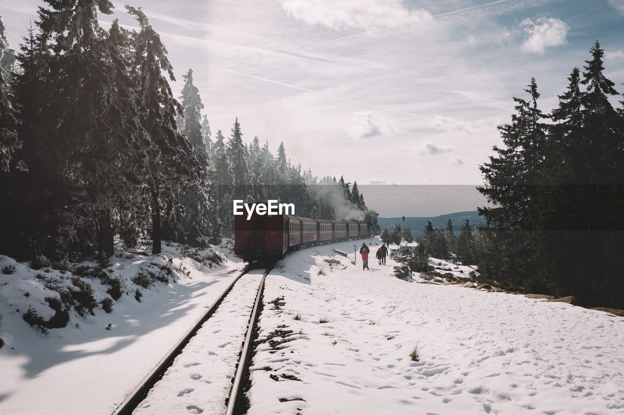 Train on track during winter against sky