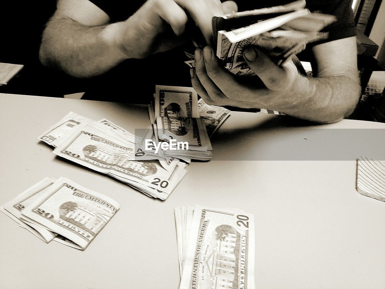 Close-up of hands holding banknotes at table