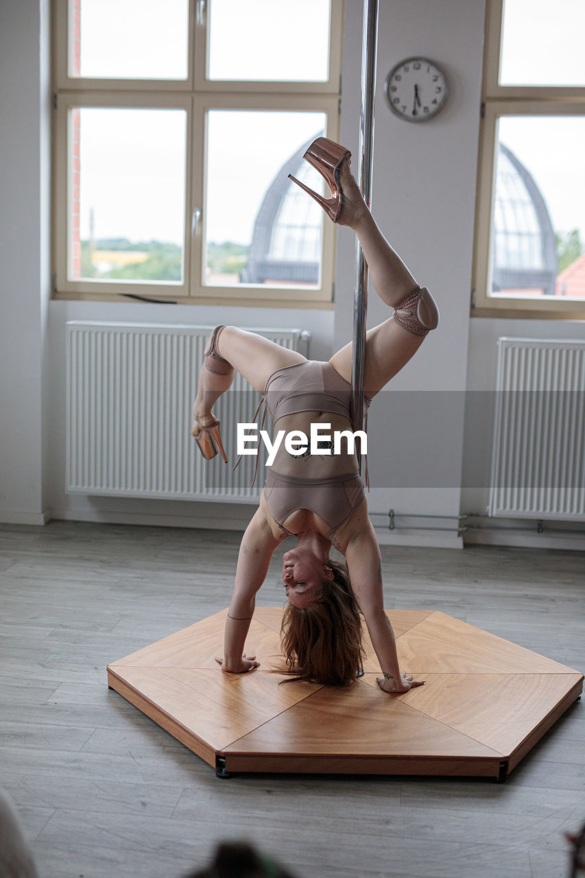 rear view of young woman sitting on table at home