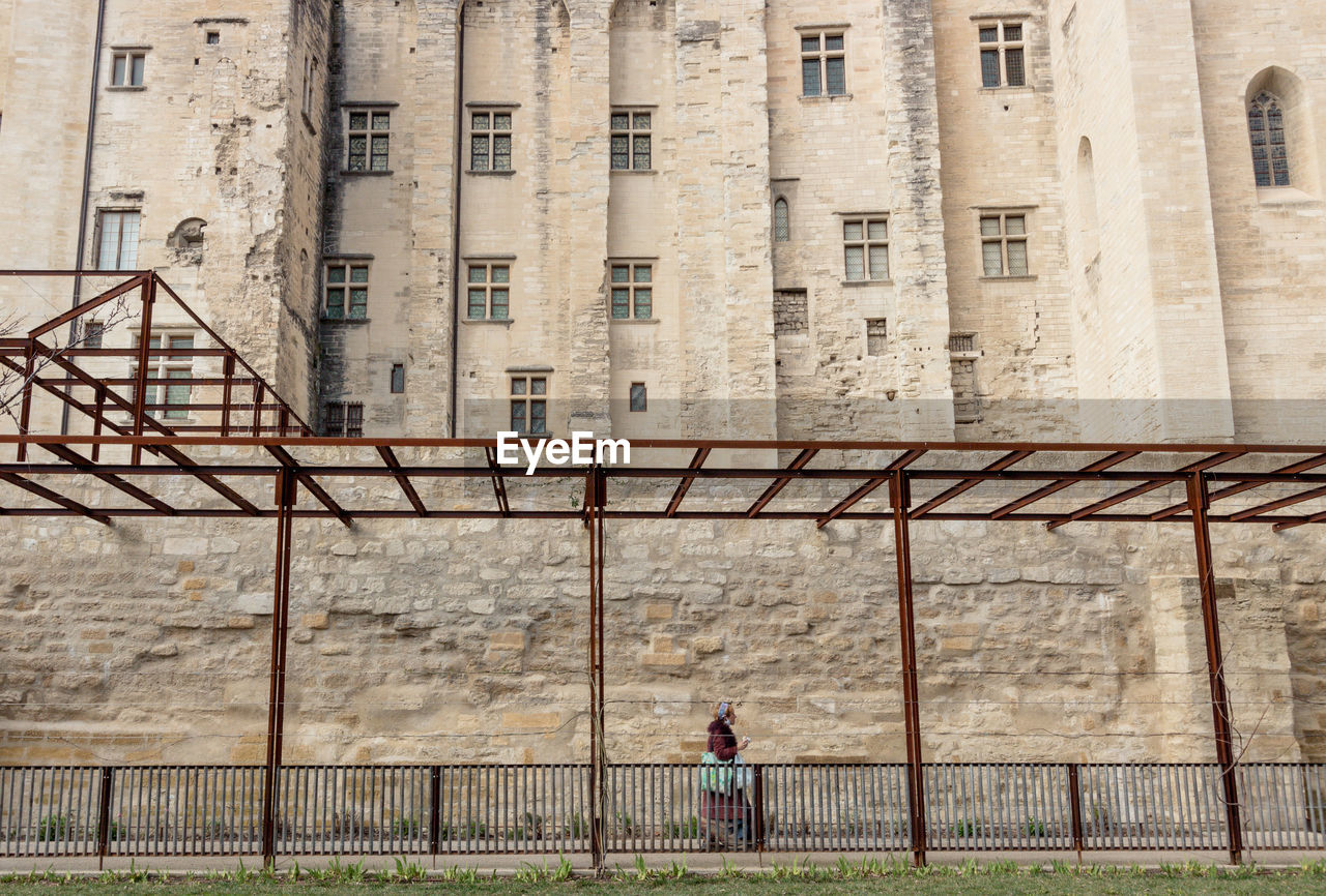 Man standing by old building in city