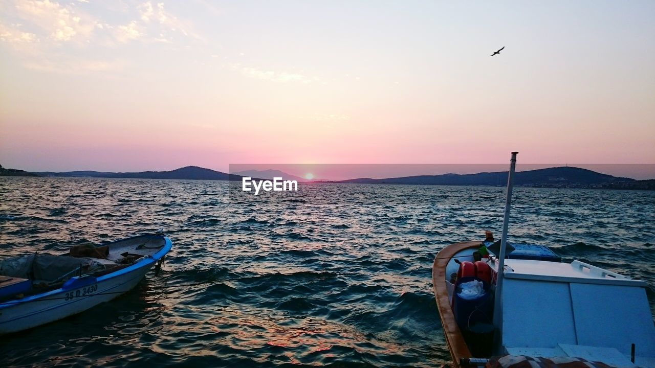 Sailboat in sea at sunset