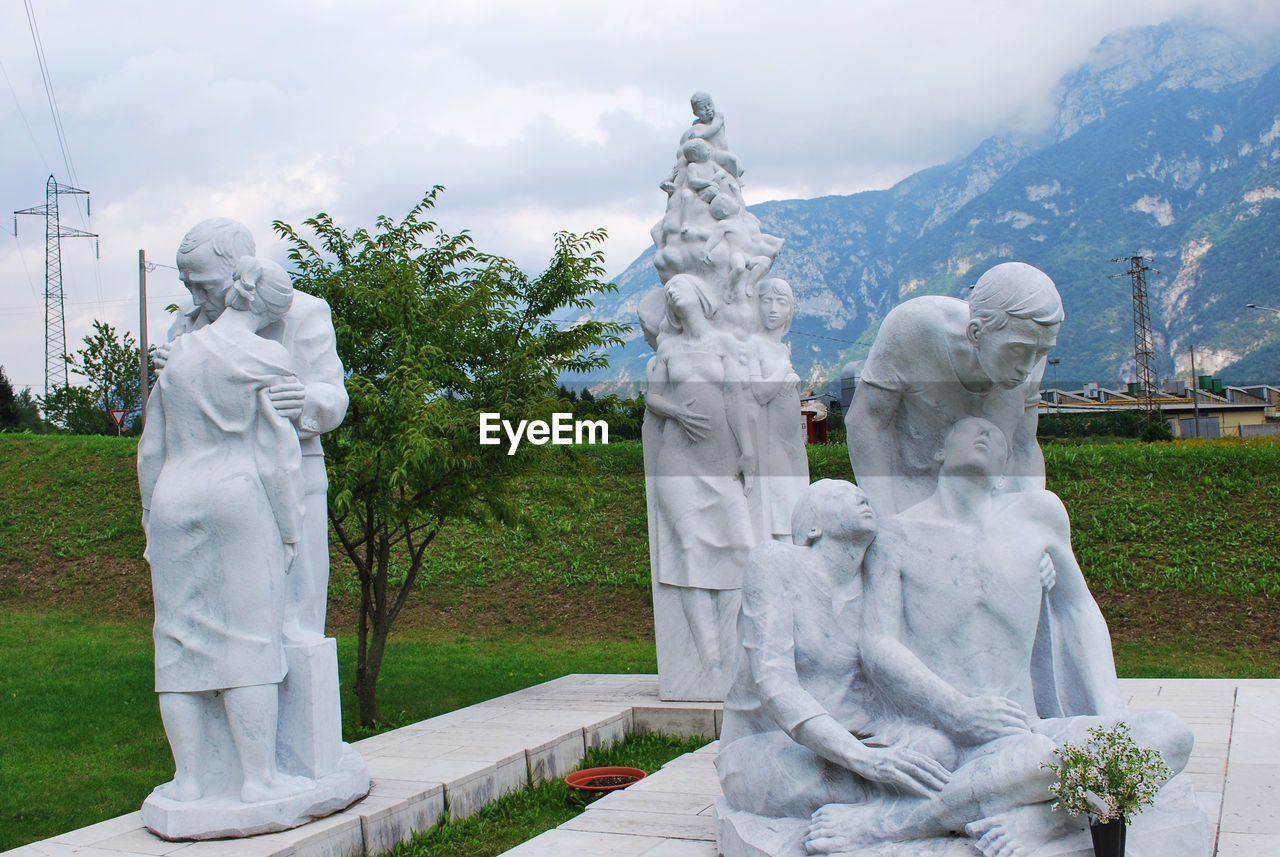 STATUE AGAINST TREES AND MOUNTAIN