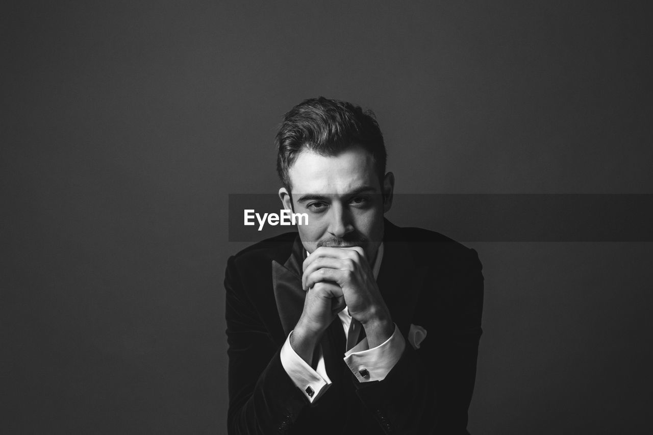 PORTRAIT OF YOUNG MAN OVER BLACK BACKGROUND