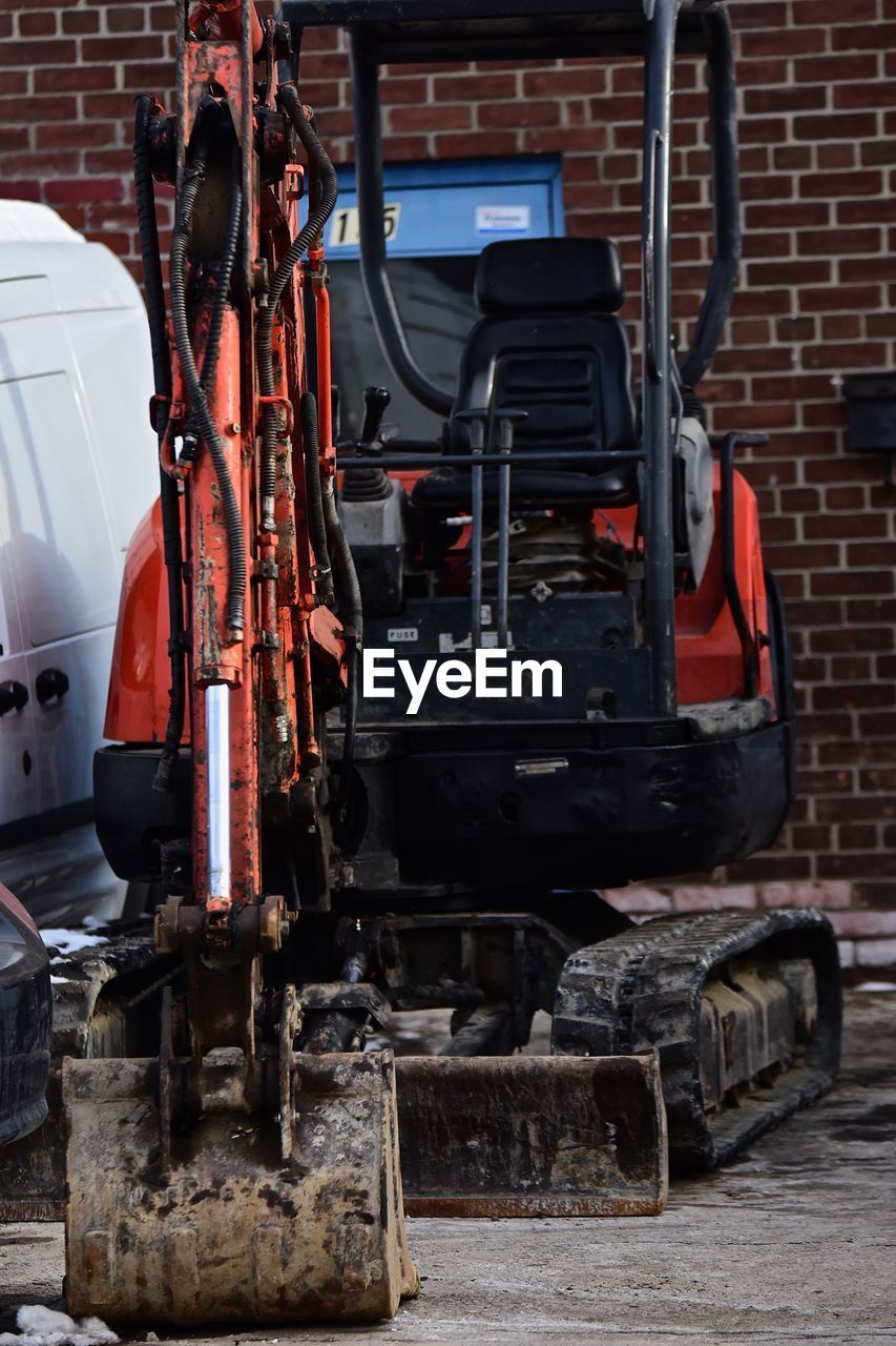 Construction vehicle against brick wall