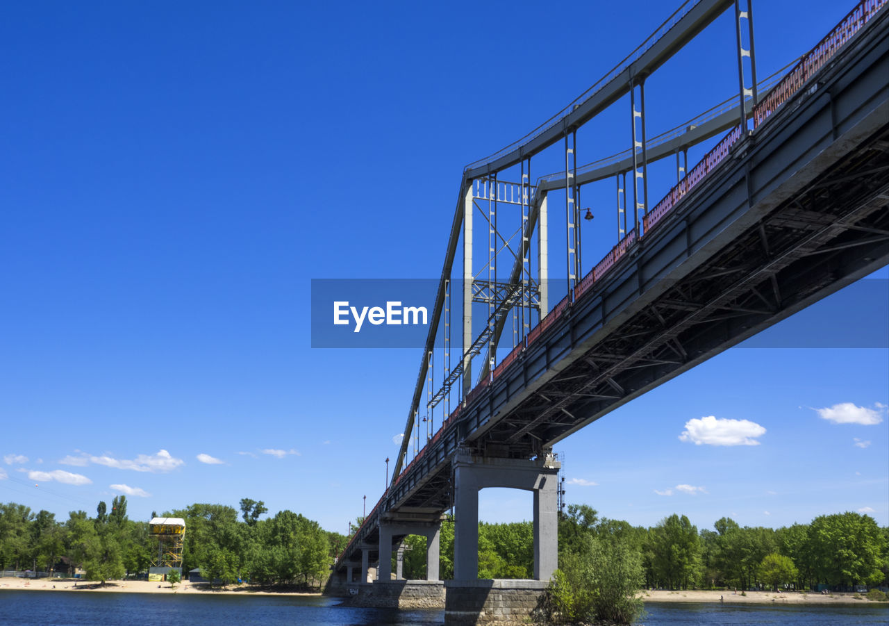 Low angle view of bridge over dnieper river at trukhanov island against sky