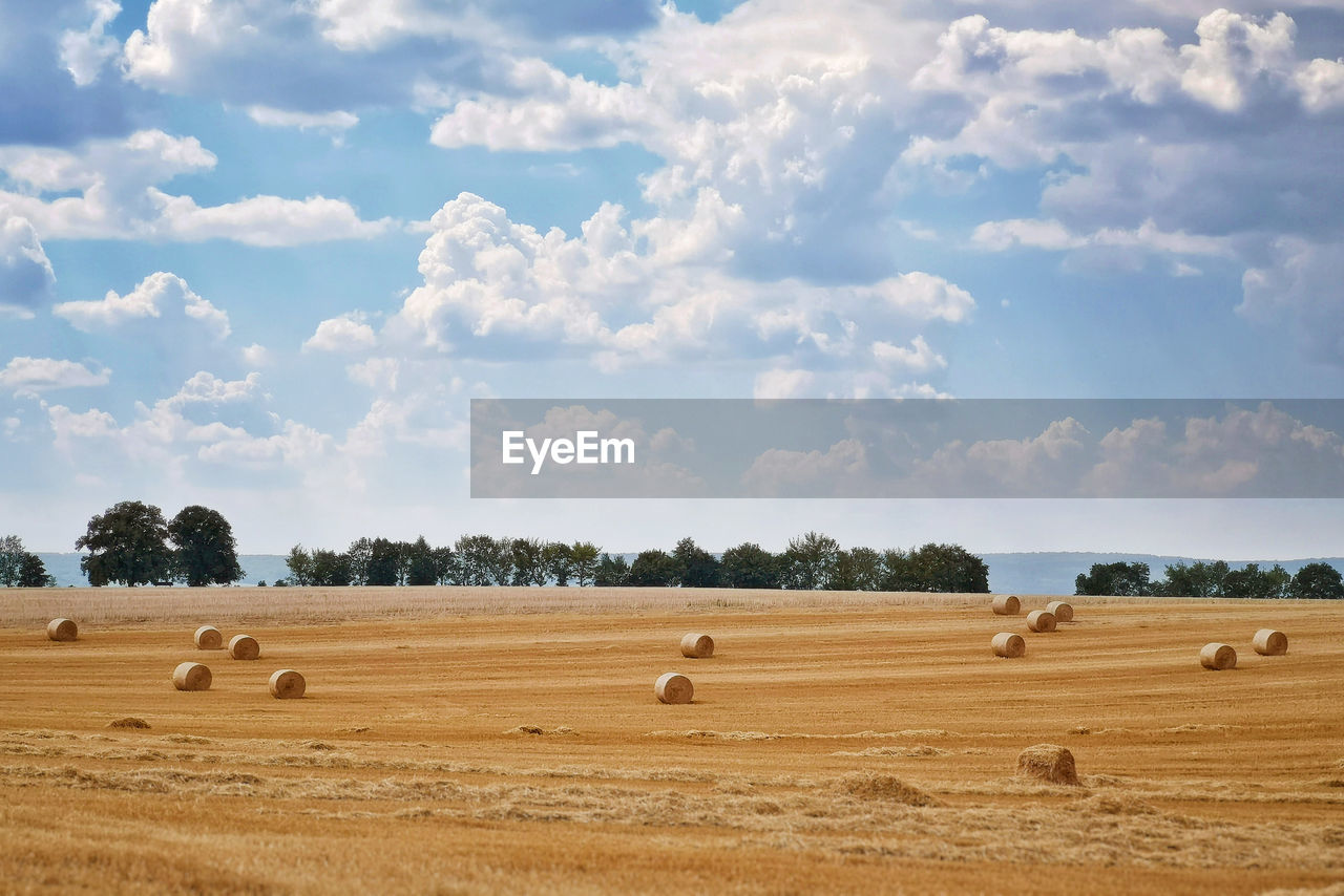 Hay bales on field against sky