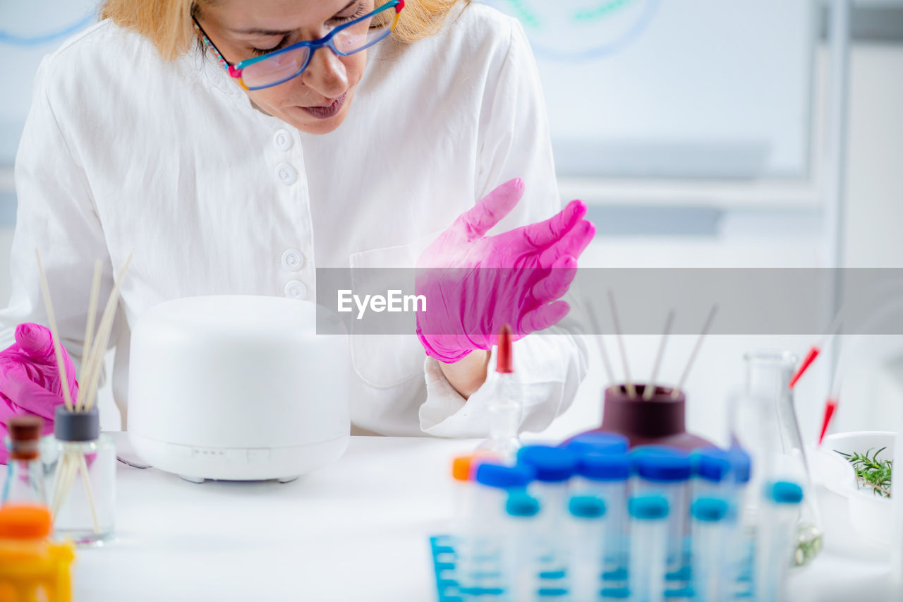 Perfumer or scientist smelling fragrance from humidifier, testing it.