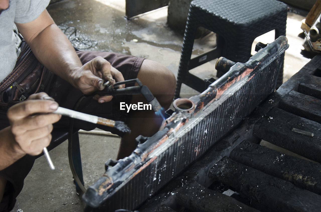 HIGH ANGLE VIEW OF MAN WORKING AT METAL CONSTRUCTION