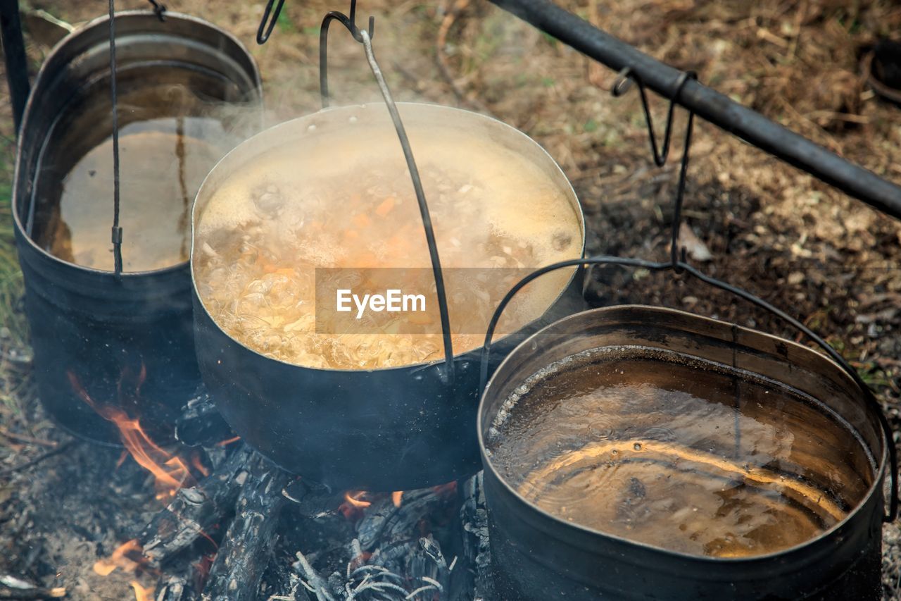 High angle view of food cooking in containers on wood burning stove