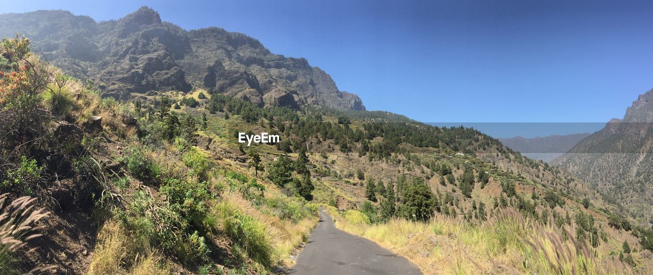 Scenic panorama view of road by mountains against clear sky