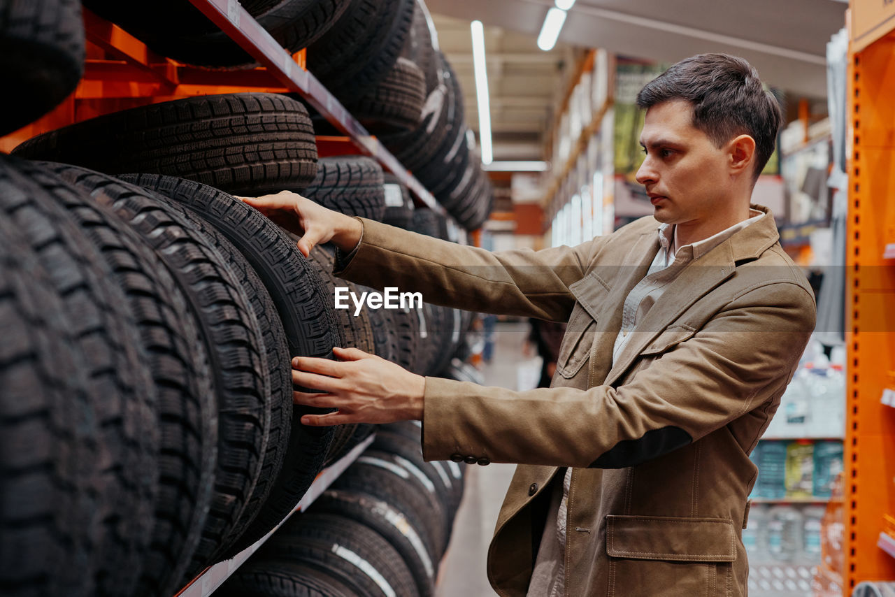 Man choosing tire at store