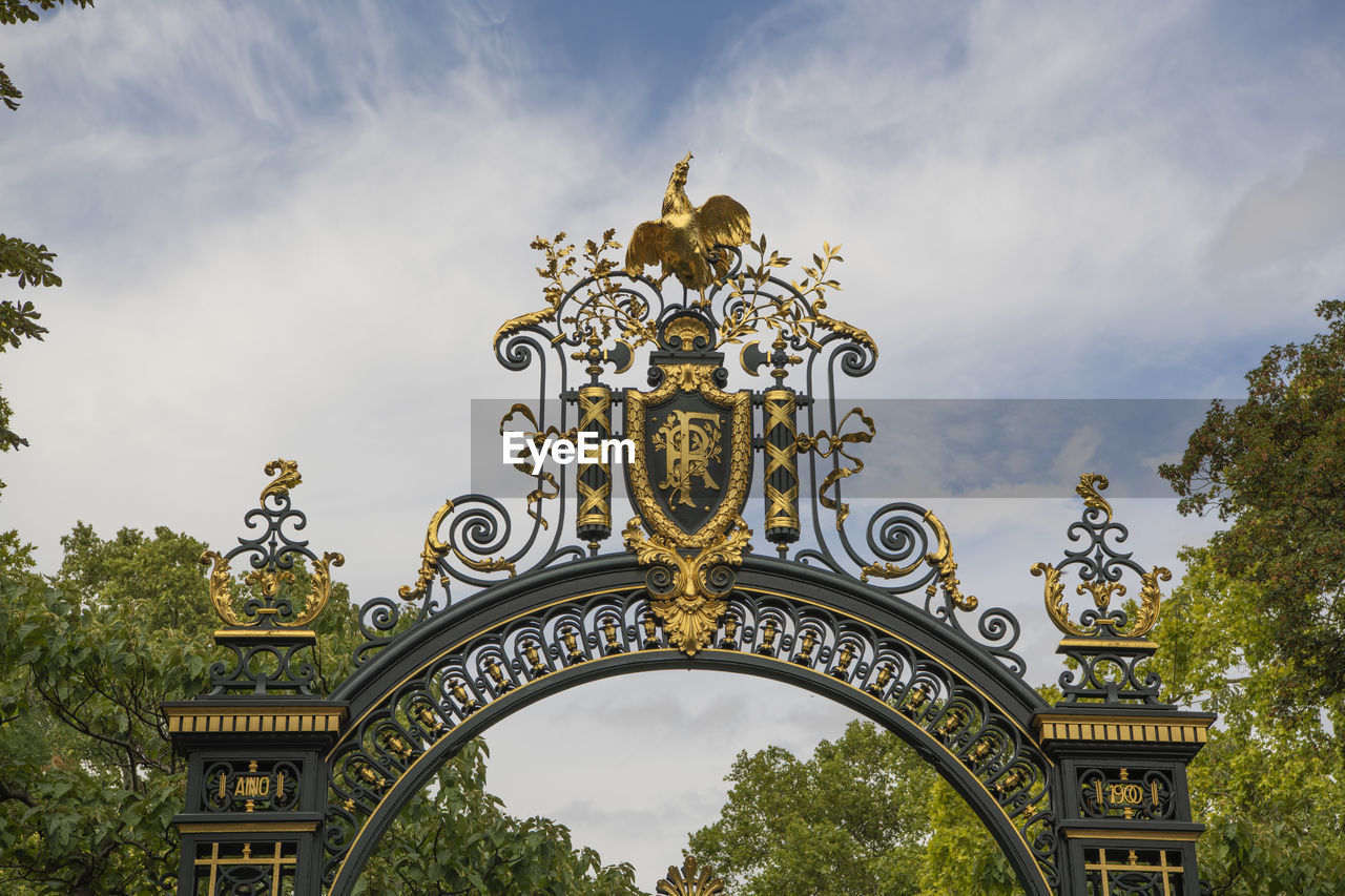 LOW ANGLE VIEW OF ORNATE GATE AGAINST SKY