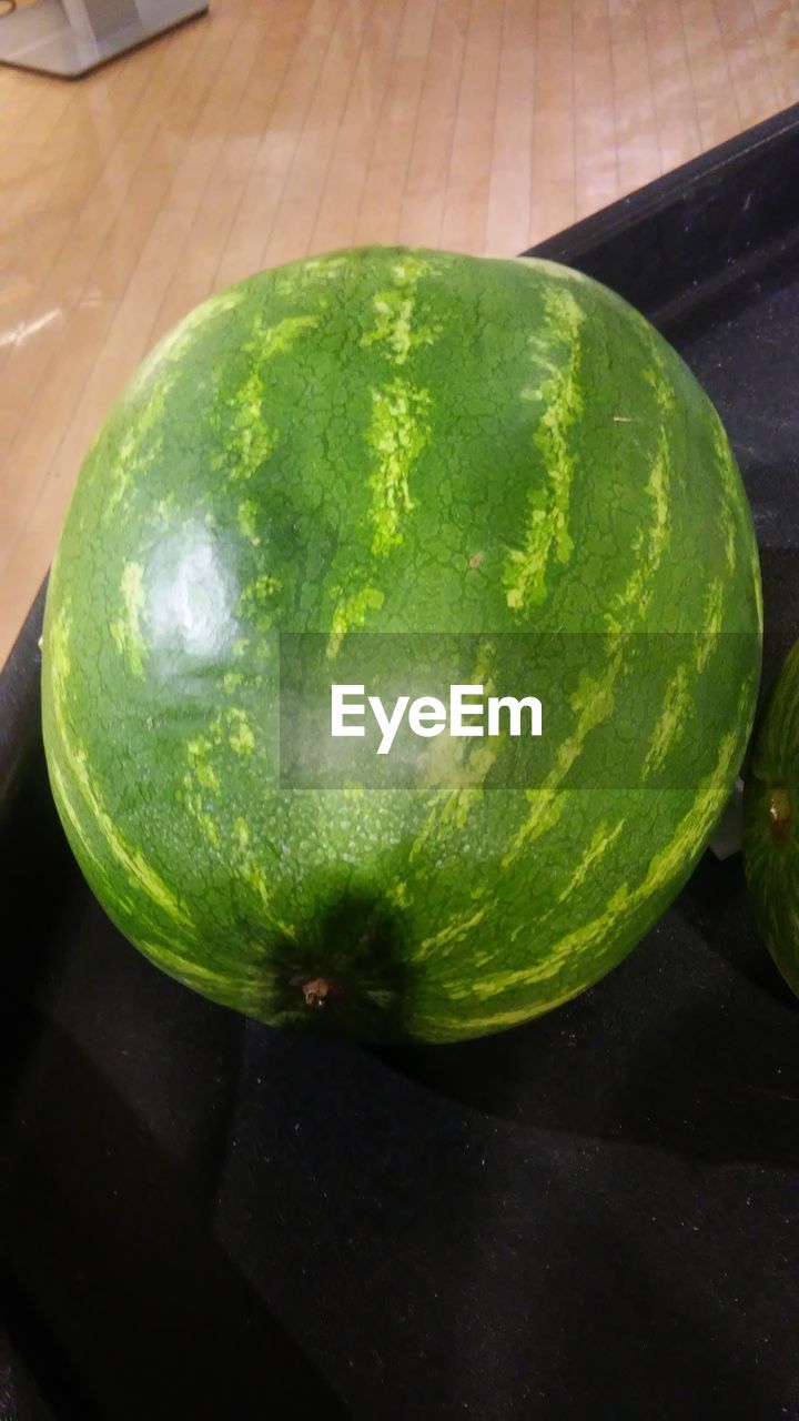 HIGH ANGLE VIEW OF GREEN LEMON ON TABLE