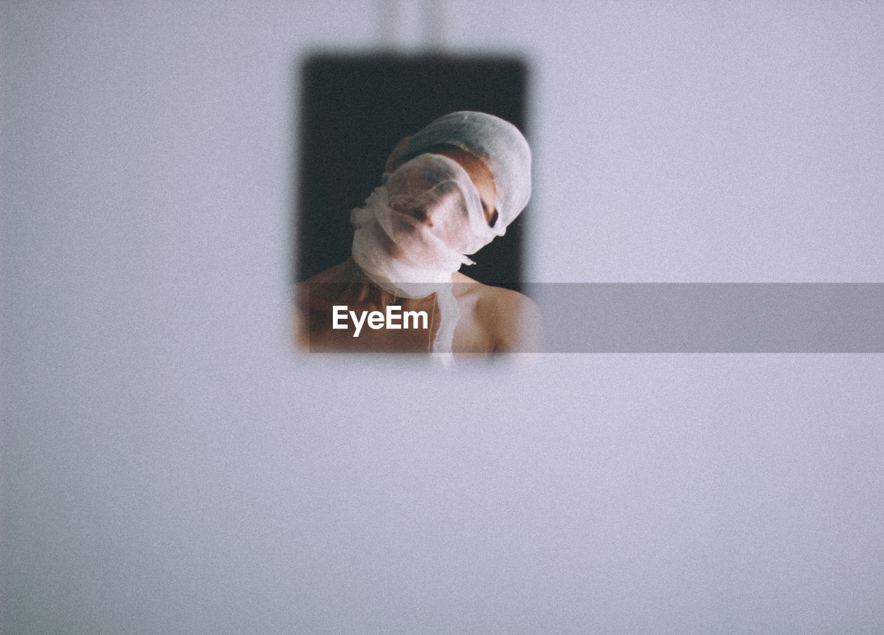 Close-up of woman with facial mask reflecting on mirror