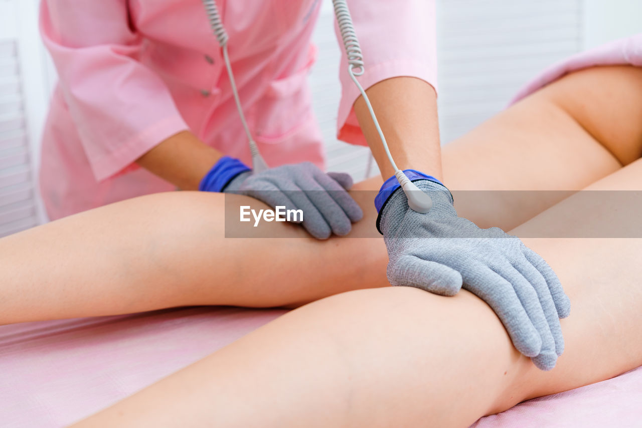 Masseuse makes an anti-cellulite massage on legs. micro-sensory electric