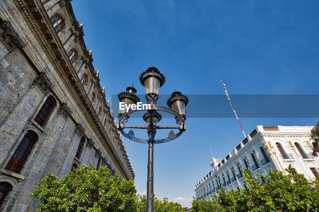 LOW ANGLE VIEW OF STREET LIGHT AGAINST BUILDINGS