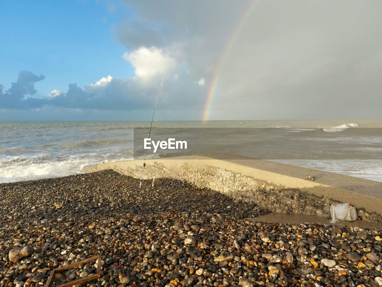 sea, water, sky, beach, land, shore, horizon, beauty in nature, coast, ocean, nature, wave, sunlight, horizon over water, sand, scenics - nature, cloud, body of water, rainbow, tranquility, pebble, tranquil scene, motion, wind wave, day, rock, no people, outdoors, idyllic, environment, seascape, coastline, stone, morning, travel destinations, water's edge, travel, non-urban scene