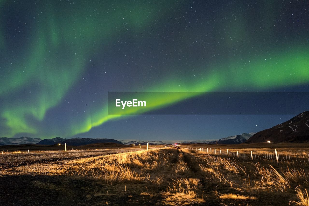 Scenic view of field against sky during aurora borealis