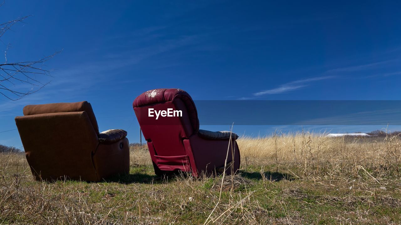 Rear view of two seats on landscape