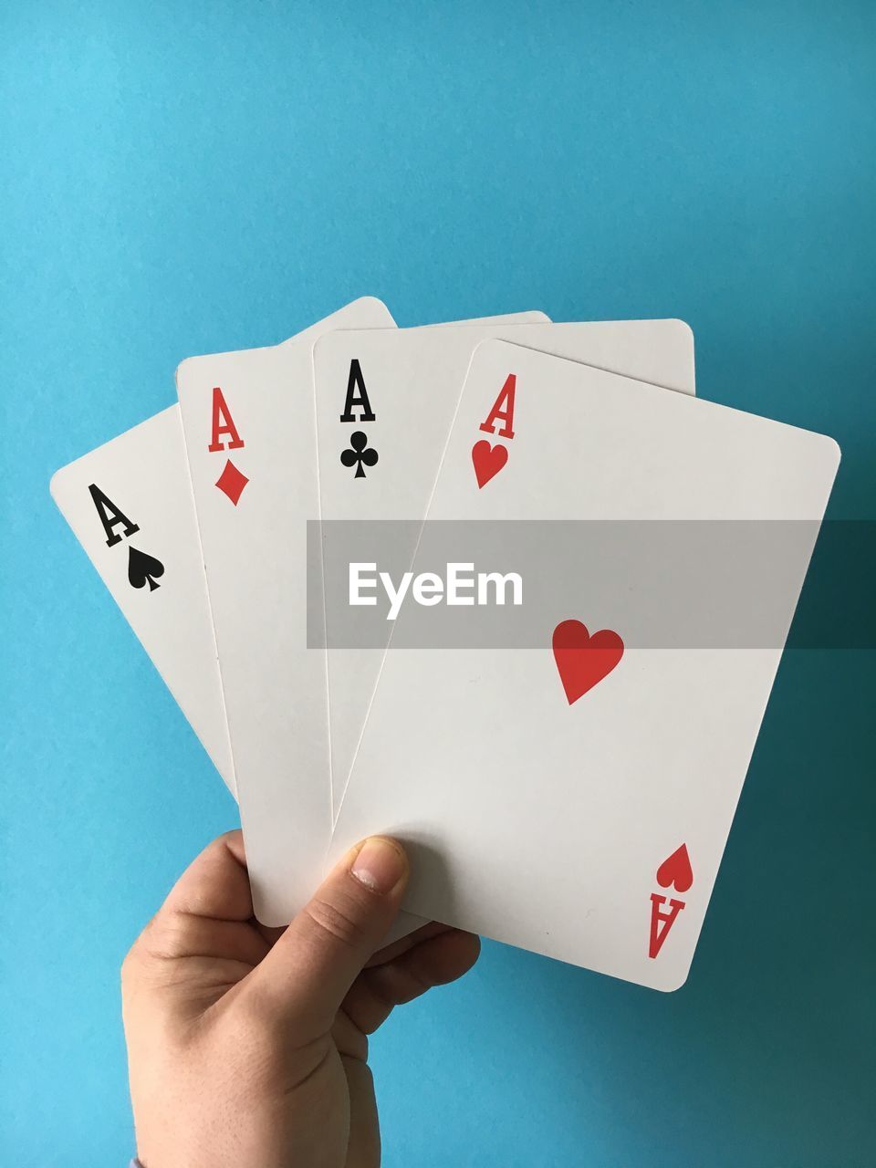 Cropped image of hand with aces cards at casino table