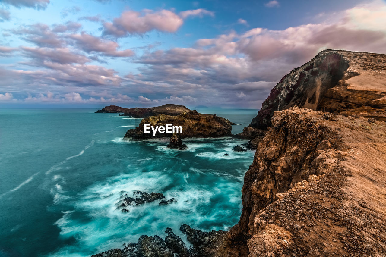 Scenic view of rocks in sea against sky