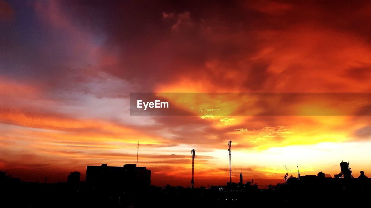 Silhouette of buildings against cloudy sky