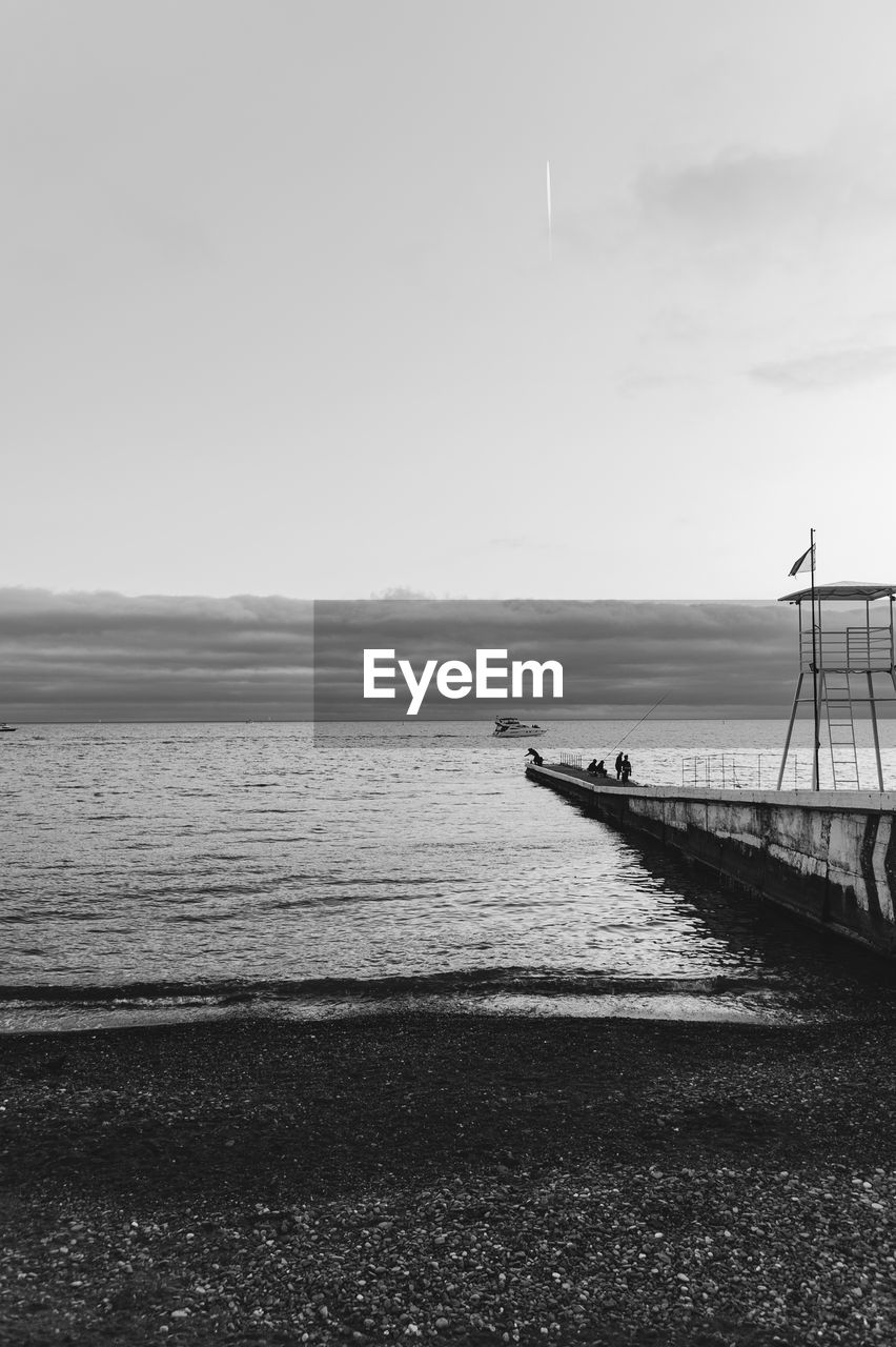 water, sea, sky, black and white, beach, nature, scenics - nature, horizon, coast, land, monochrome photography, monochrome, shore, beauty in nature, tranquility, ocean, tranquil scene, transportation, nautical vessel, day, no people, wave, pier, horizon over water, outdoors, non-urban scene, idyllic, cloud, travel, white, mode of transportation, architecture, travel destinations, sand, environment, vehicle, copy space, built structure, holiday, body of water