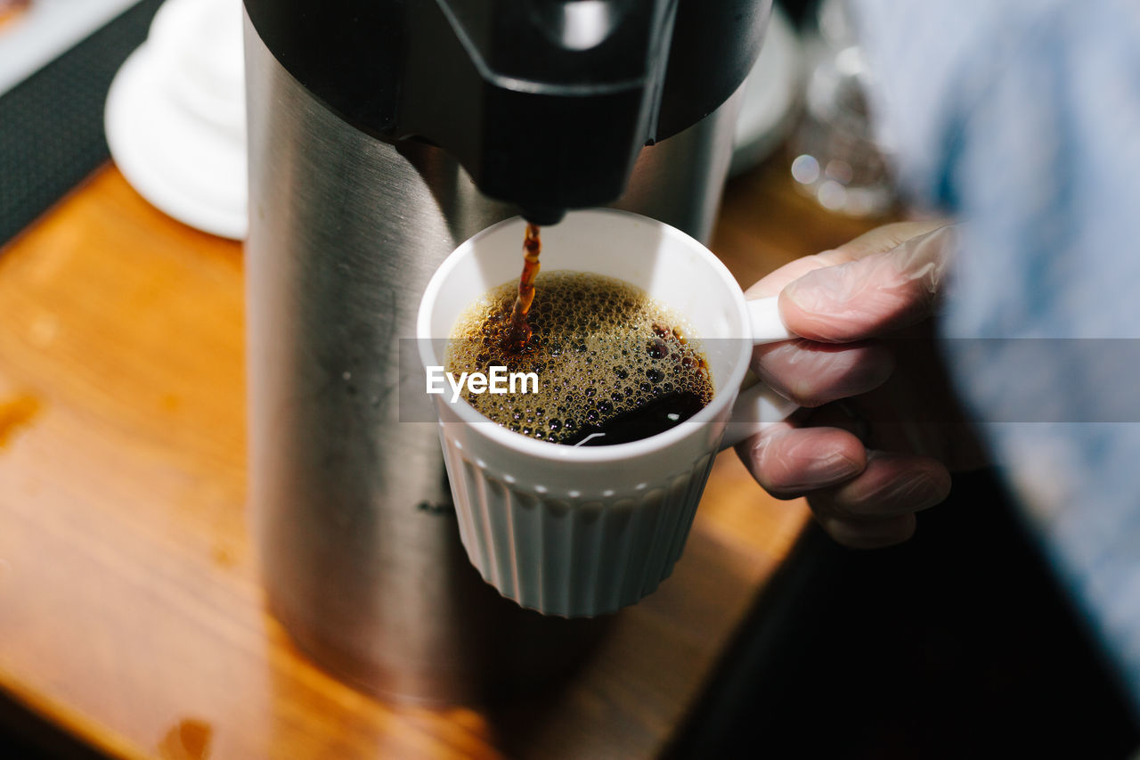 Cropped image of hand holding coffee cup