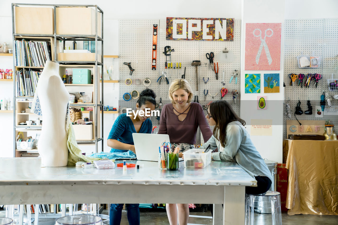 Businesswomen working on laptop computer in creative office