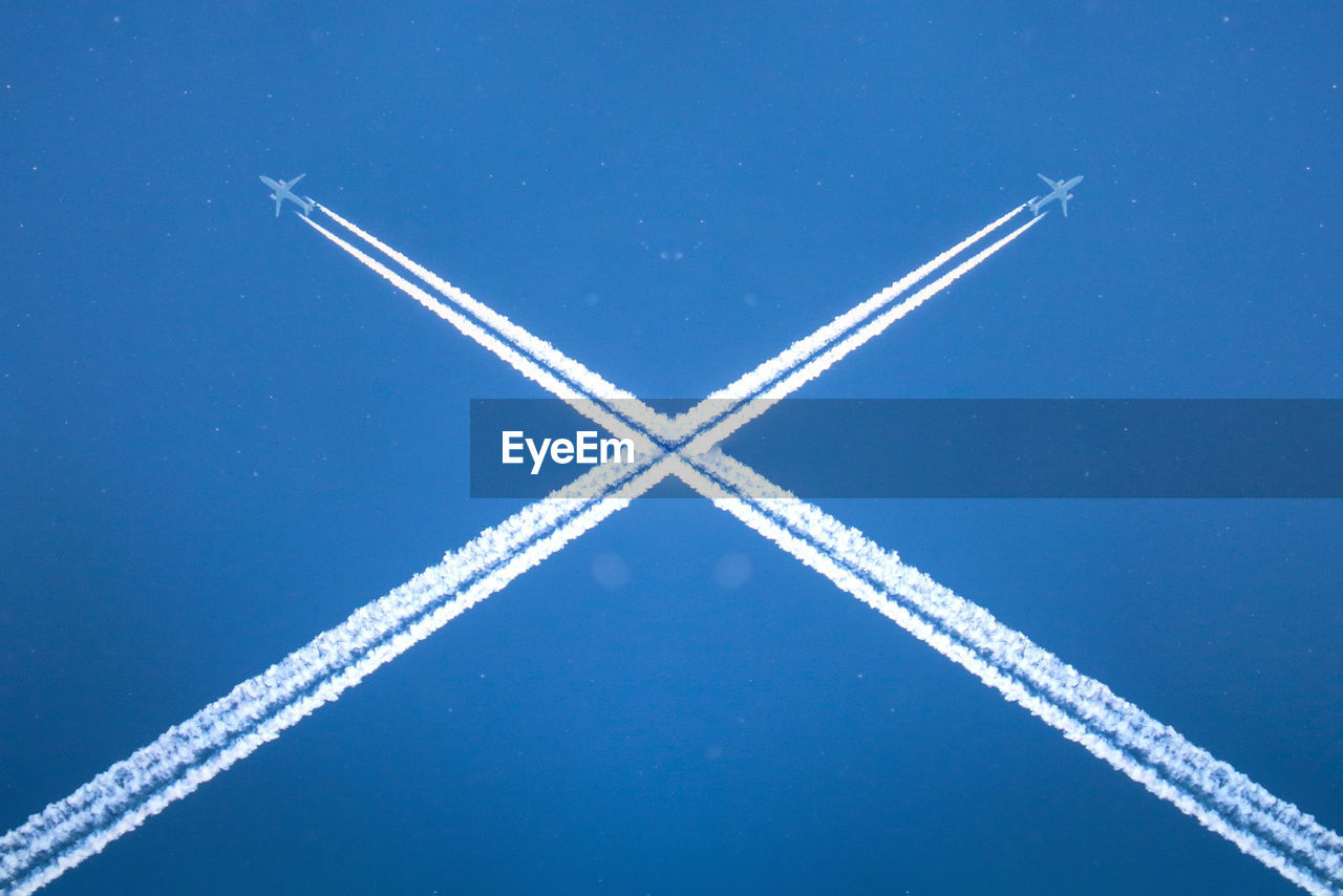 Low angle view of vapor trail against blue sky